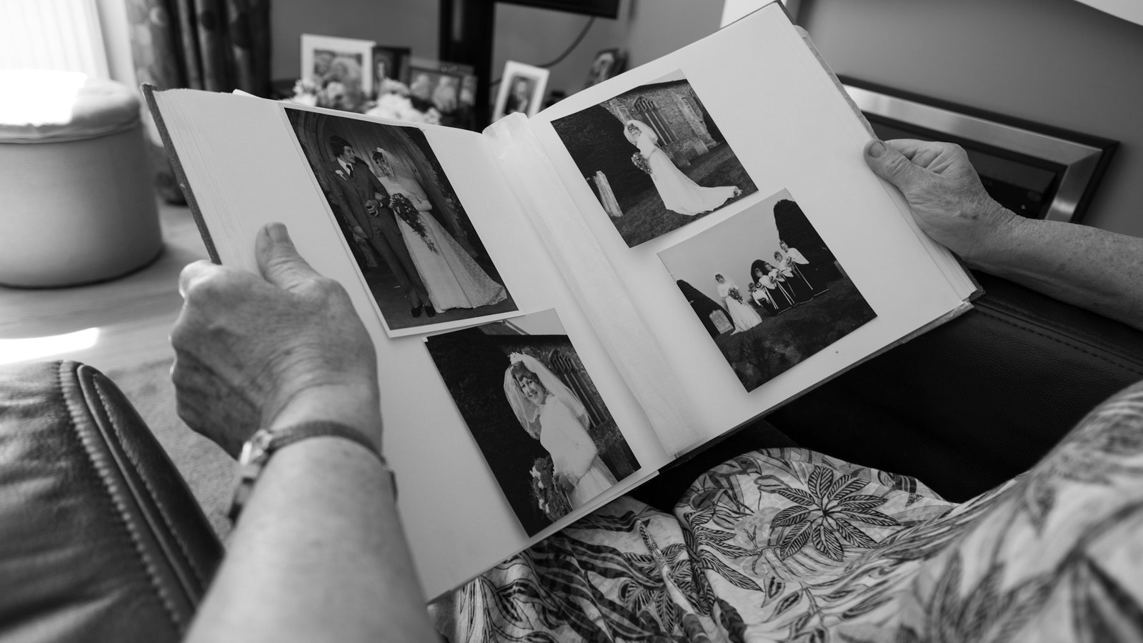 Mains d’une personne âgée feuilletant un album de photographies