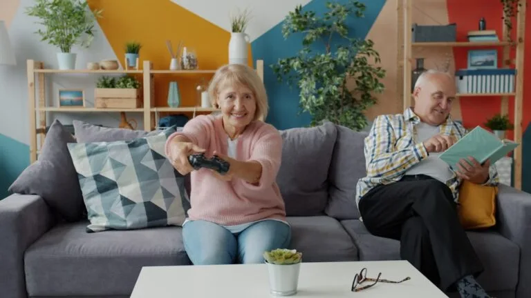 Couple de seniors sur un canapé, une paire de lunettes posée sur la table basse