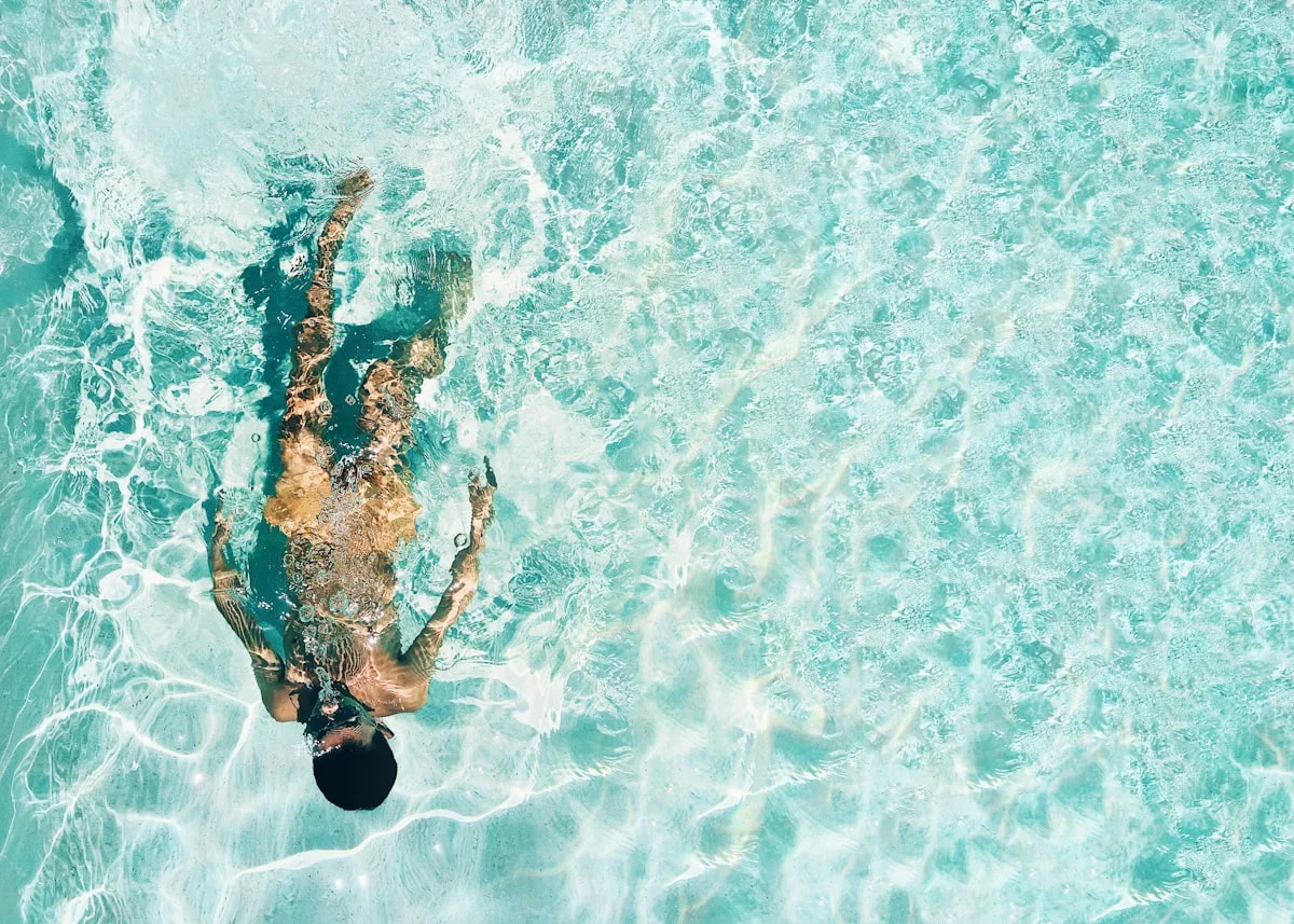 person swimming underwater in a pool