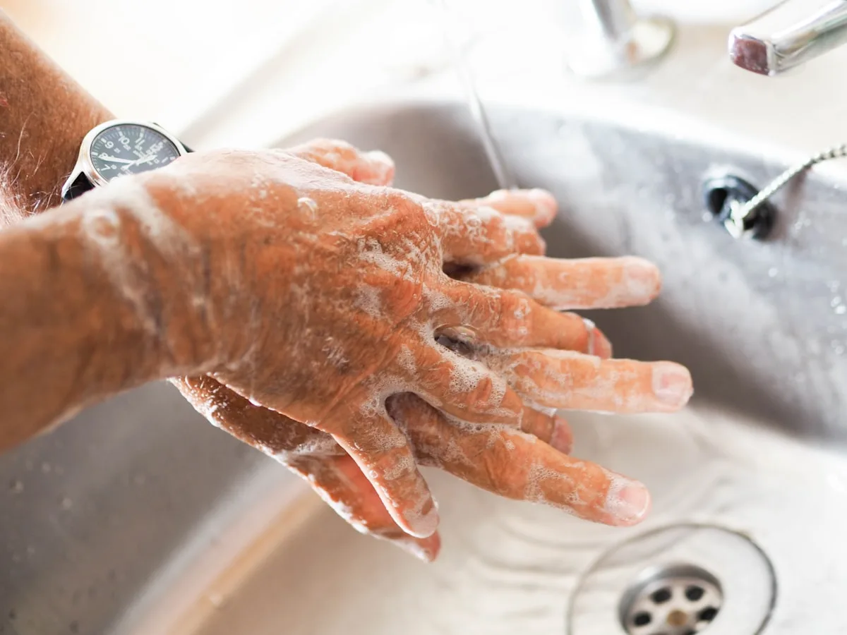 person washing their hands at a sink