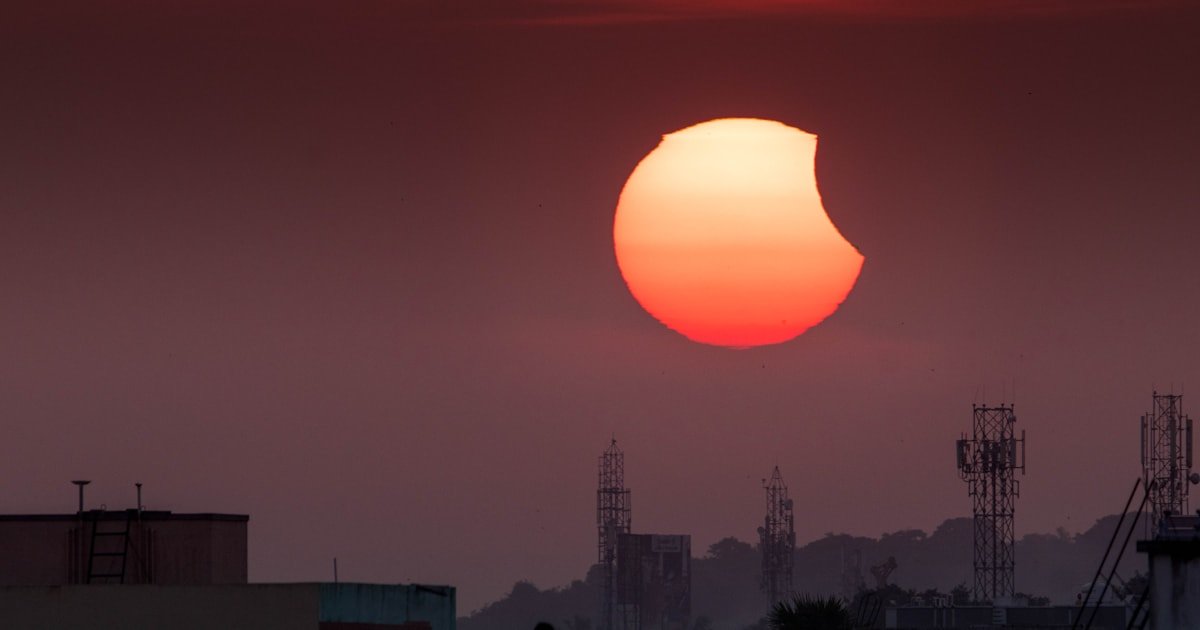 Eclipse solar parcial sobre uma cidade, Sol baixo no horizonte ao fim da tarde