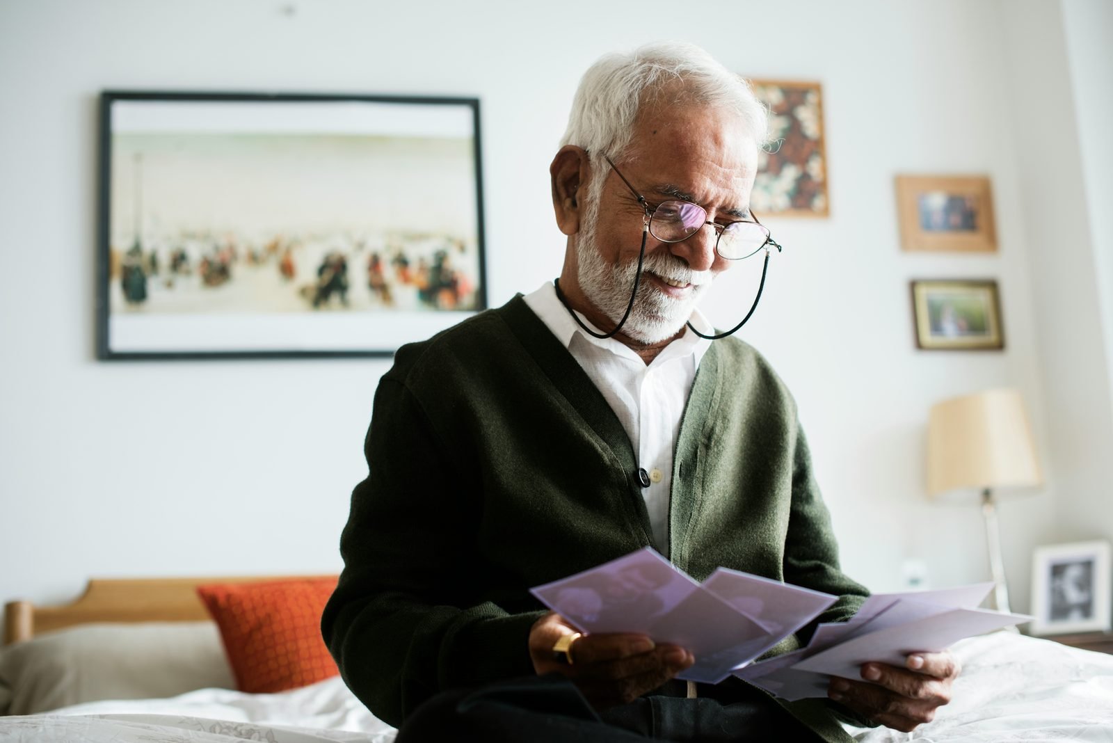 Homme âgé lisant un document près d'une fenêtre