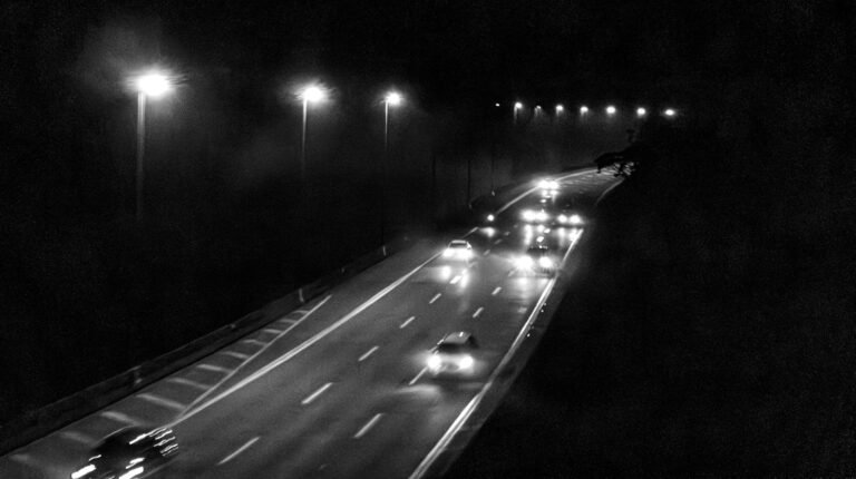 Voitures sur une route de nuit, phares et éclairage urbain