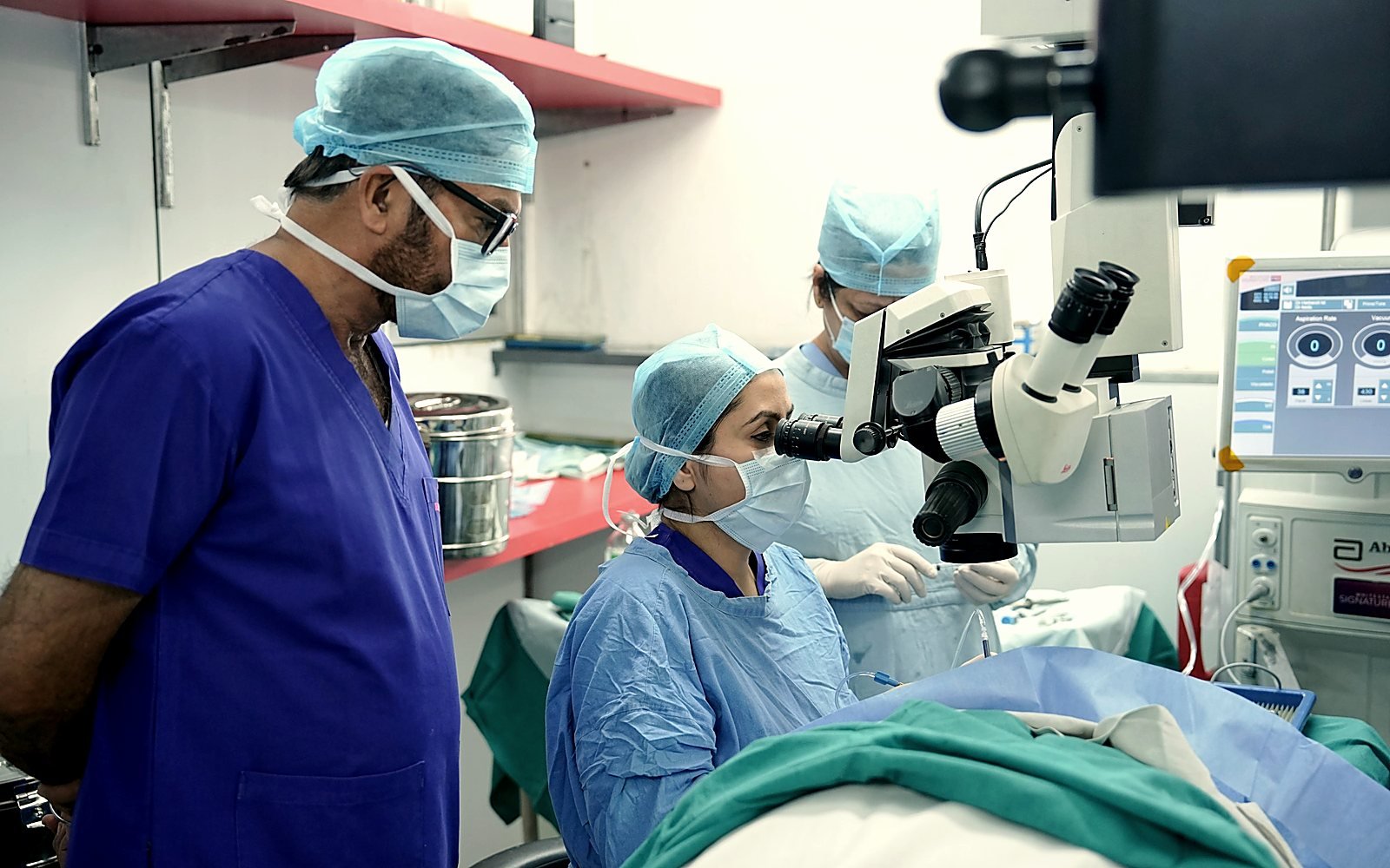 Chirurgien ophtalmologue opérant sous microscope opératoire en bloc
