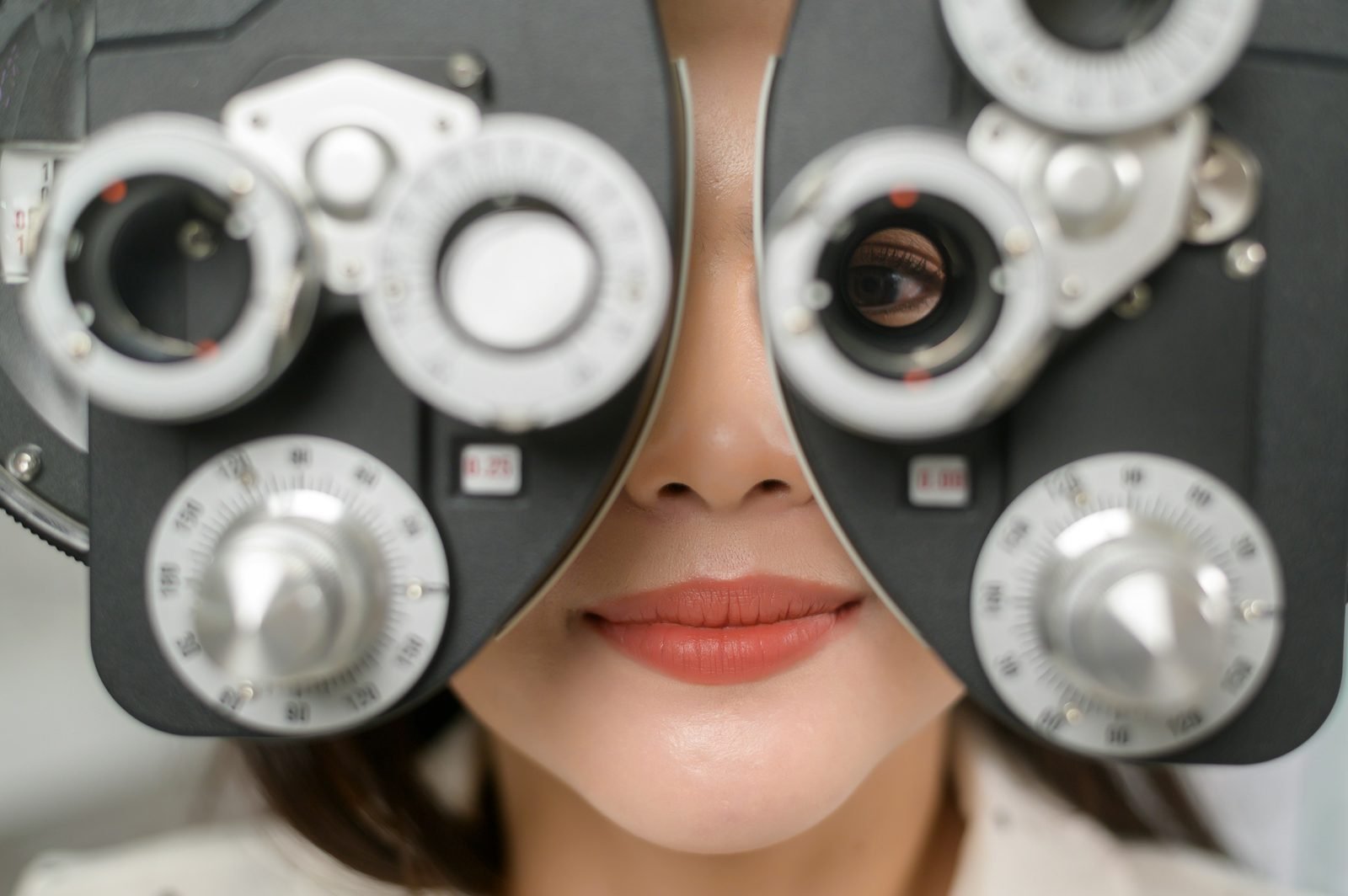 Visage d'une patiente derrière un réfracteur d'examen de la vue