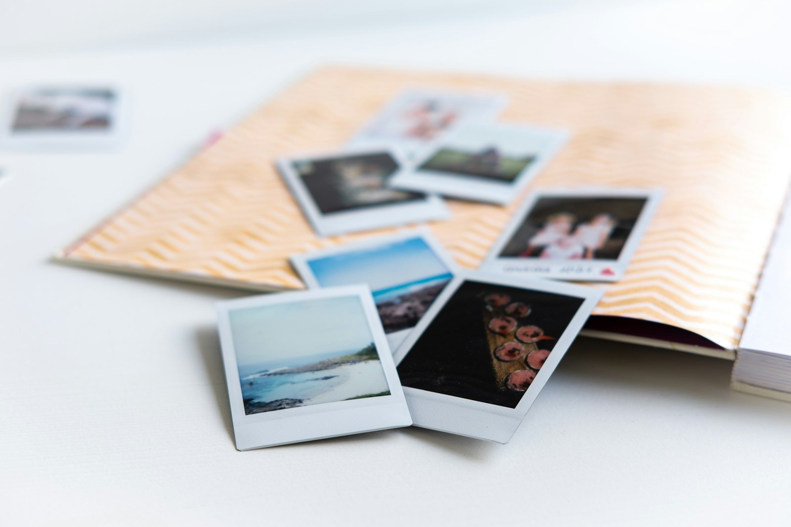 Photographic prints and an open album lying on a pale table
