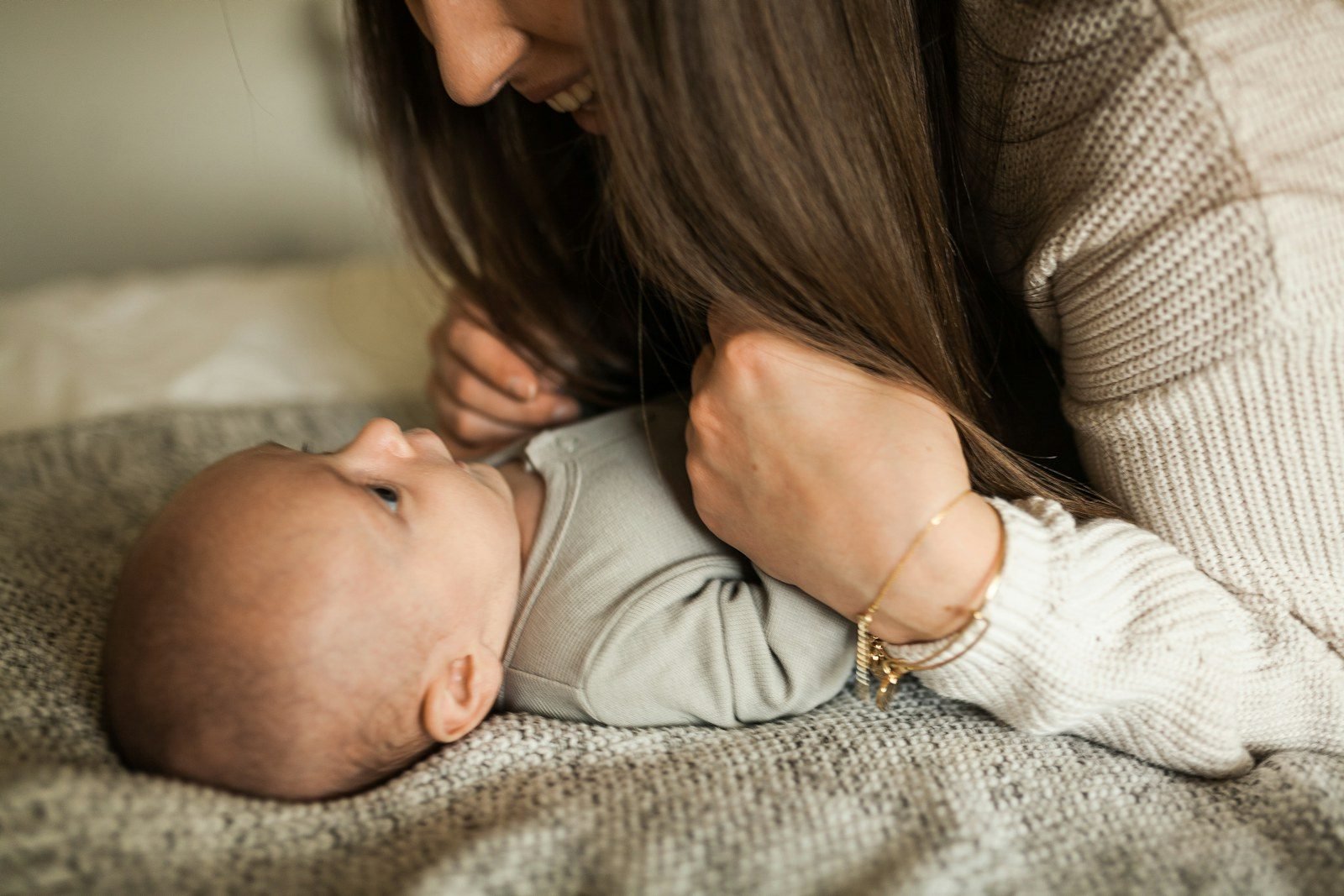 An adult holds an infant face to face, close together