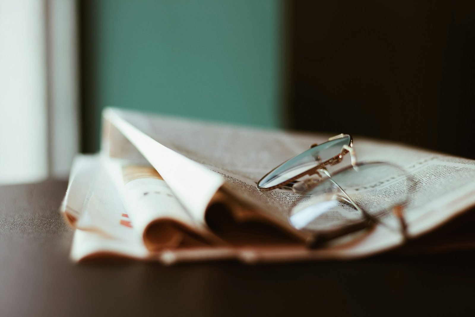 Lunettes de lecture posées sur un journal plié