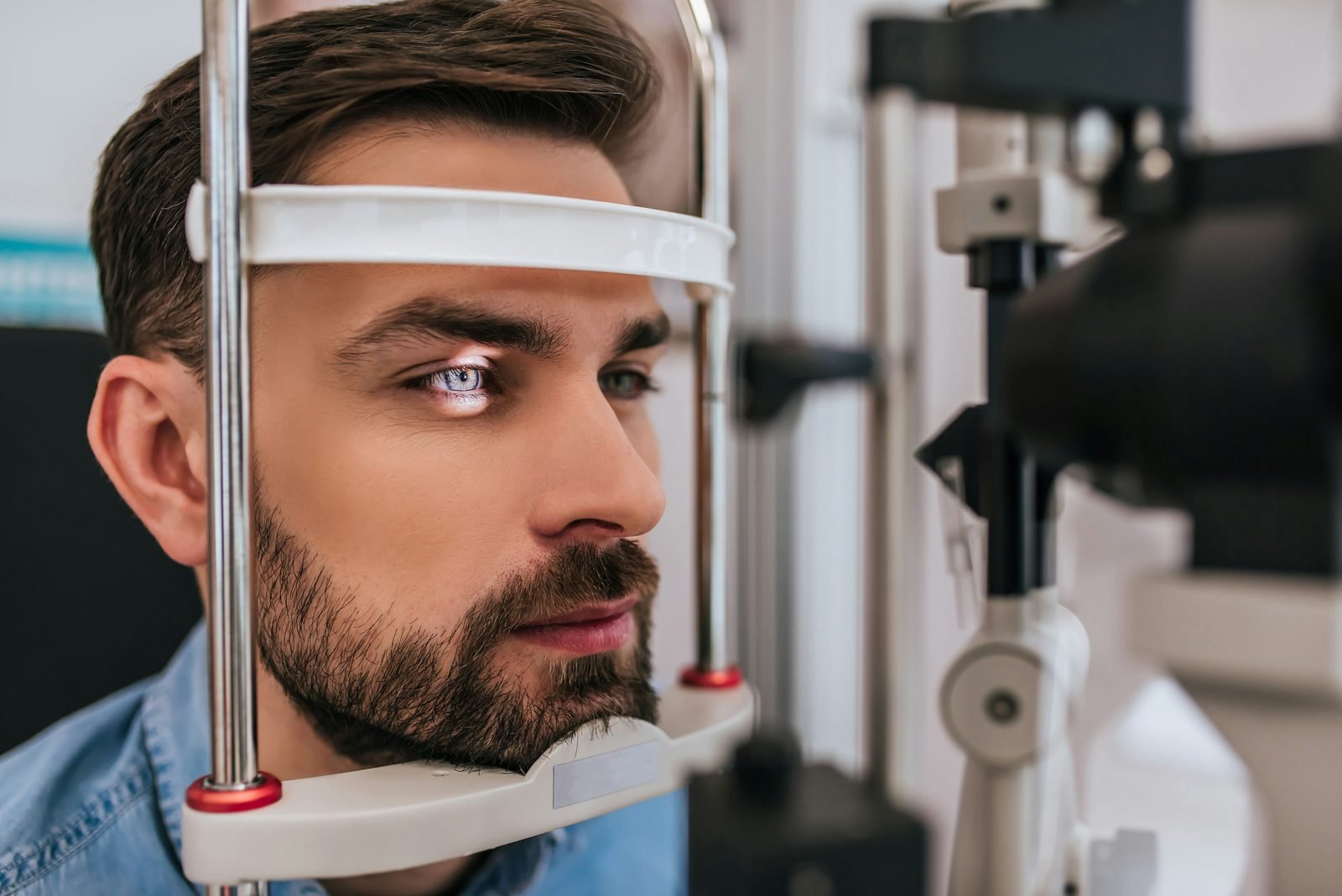 Patient installé devant un appareil d'examen ophtalmologique, menton et front en appui