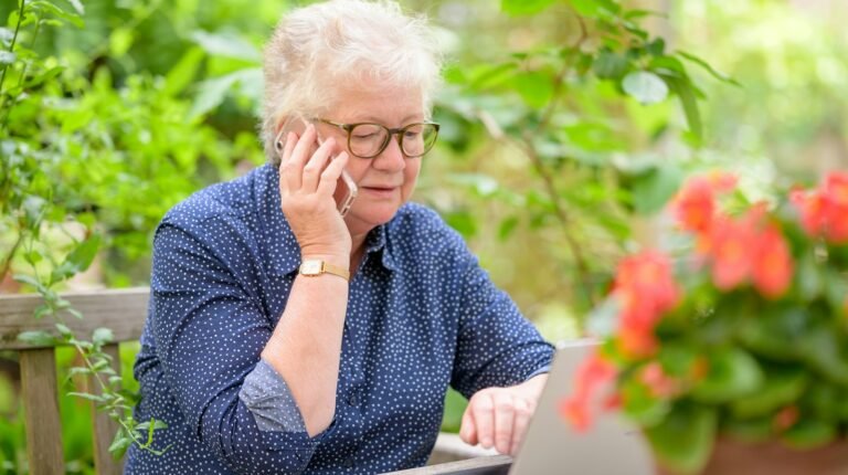 Femme senior lisant sur un ordinateur portable sans lunettes, illustration de la vision intermédiaire après implant monofocal plus