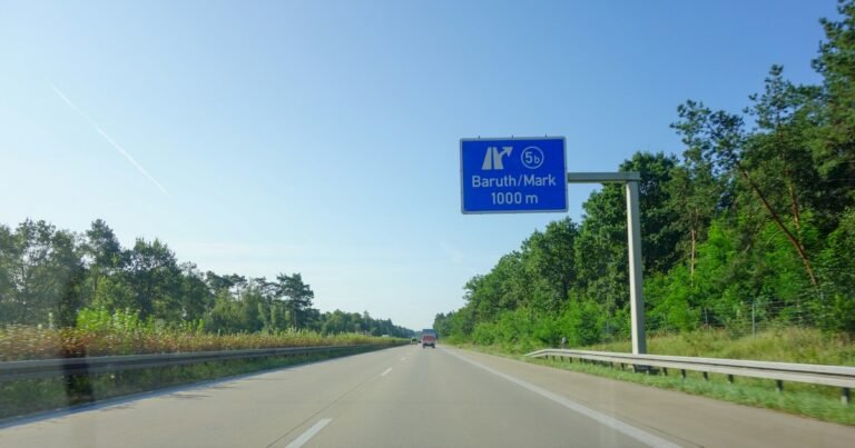 Road sign in the distance on a motorway, seen from the road