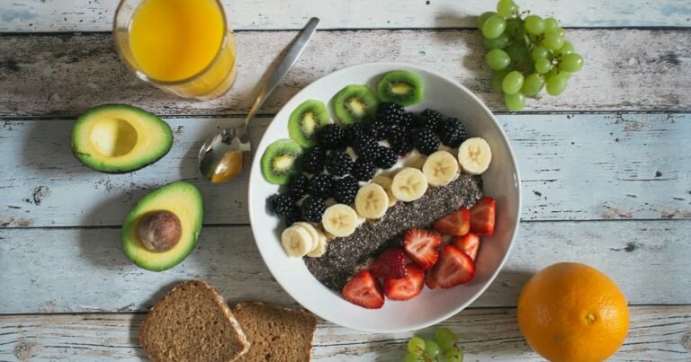 Balanced breakfast: fruit bowl, avocado, wholegrain bread and an orange