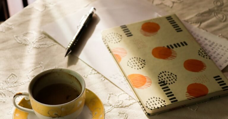Notebook, pen and a cup of coffee on a table