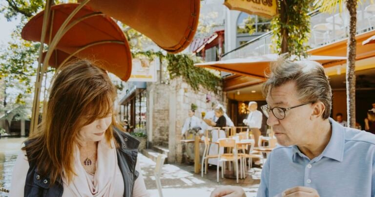 Older couple reading at a café terrace
